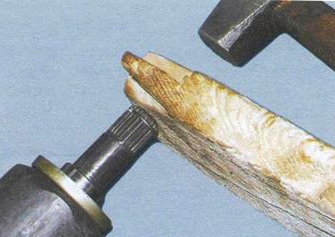 Осторожными ударами молотка через деревянный брусок забиваем новый ШРУС на место